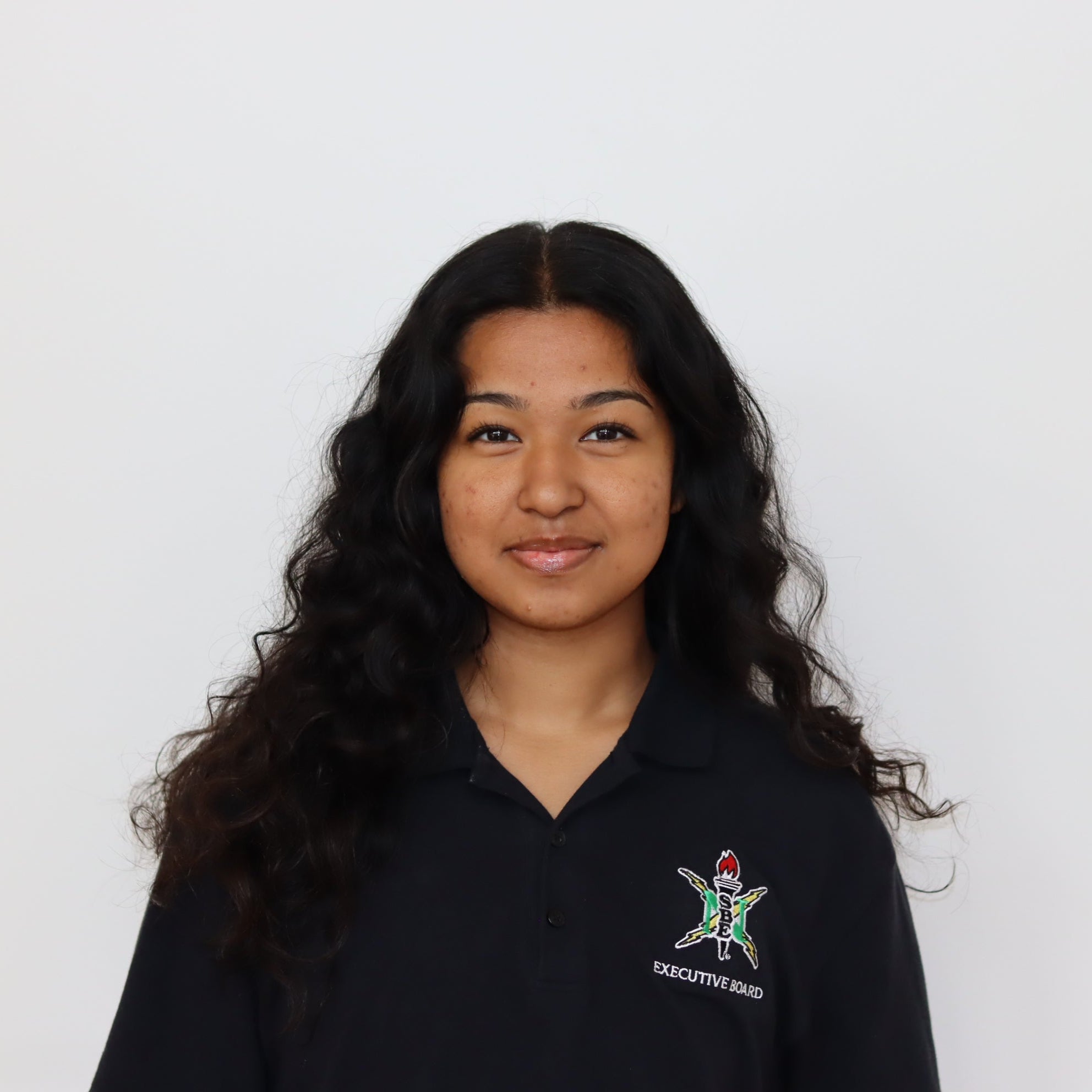 Person wearing a black polo shirt with a logo on a white background
