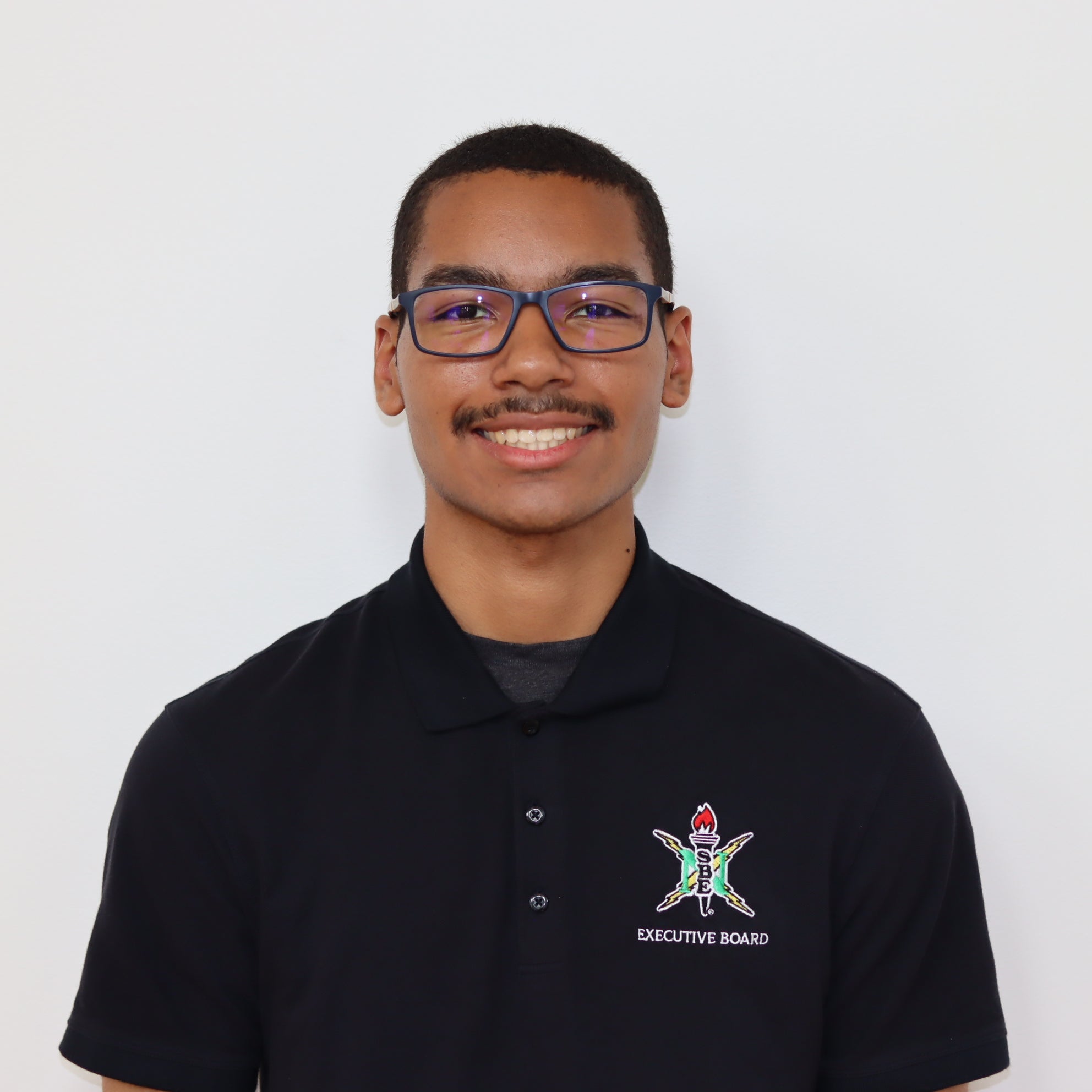 Person wearing a black polo shirt with an embroidered logo on a white background