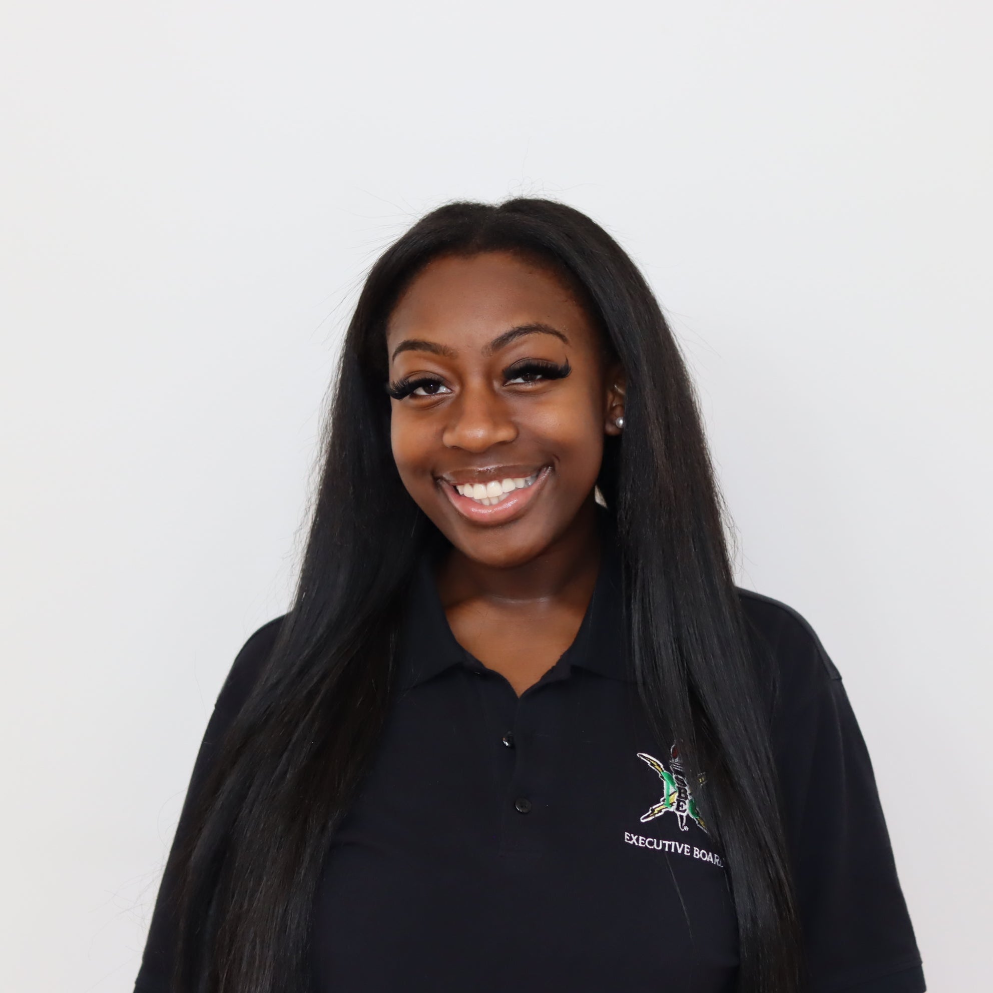 Woman wearing a black polo shirt with a logo on a white background