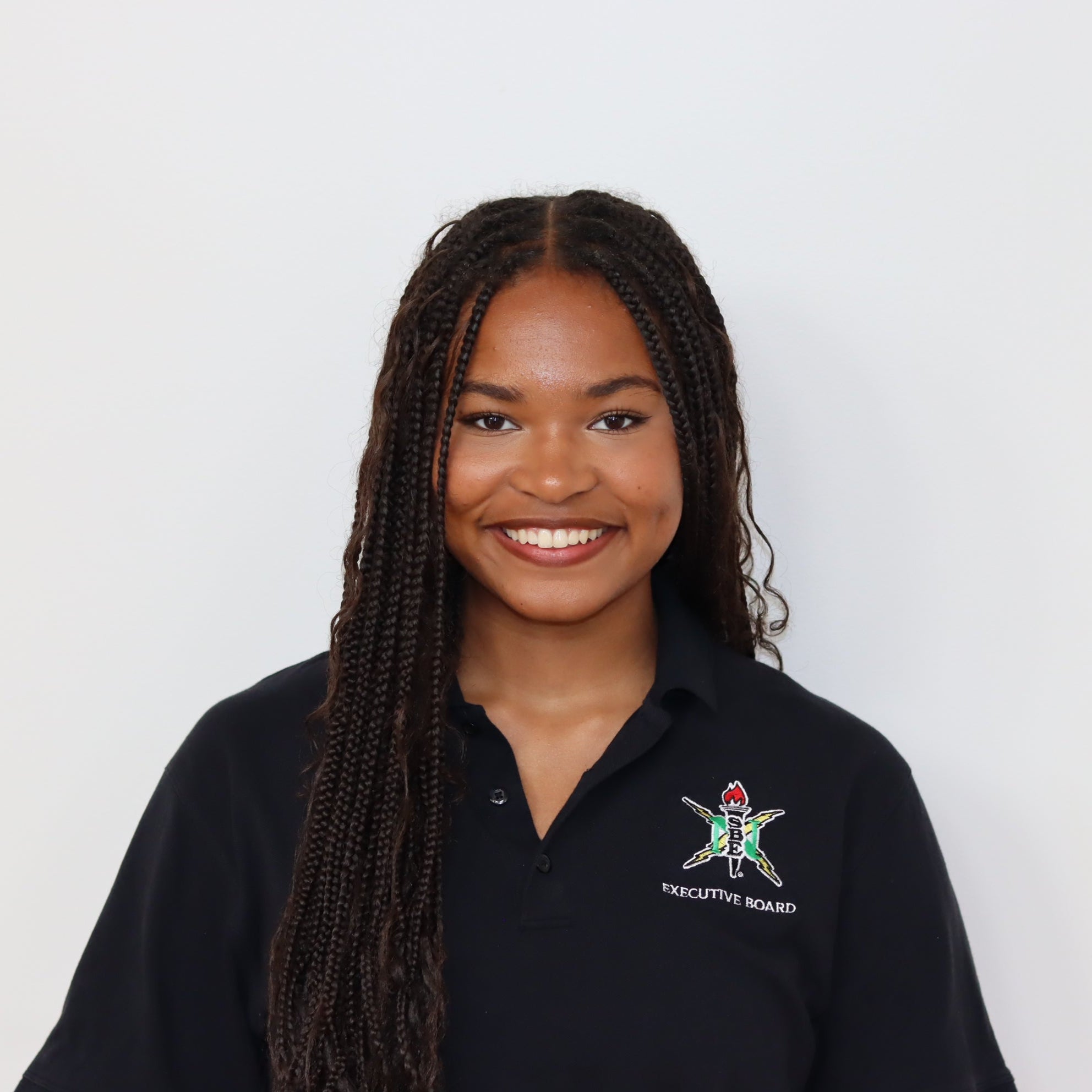 Person wearing a black polo shirt with a logo on a white background