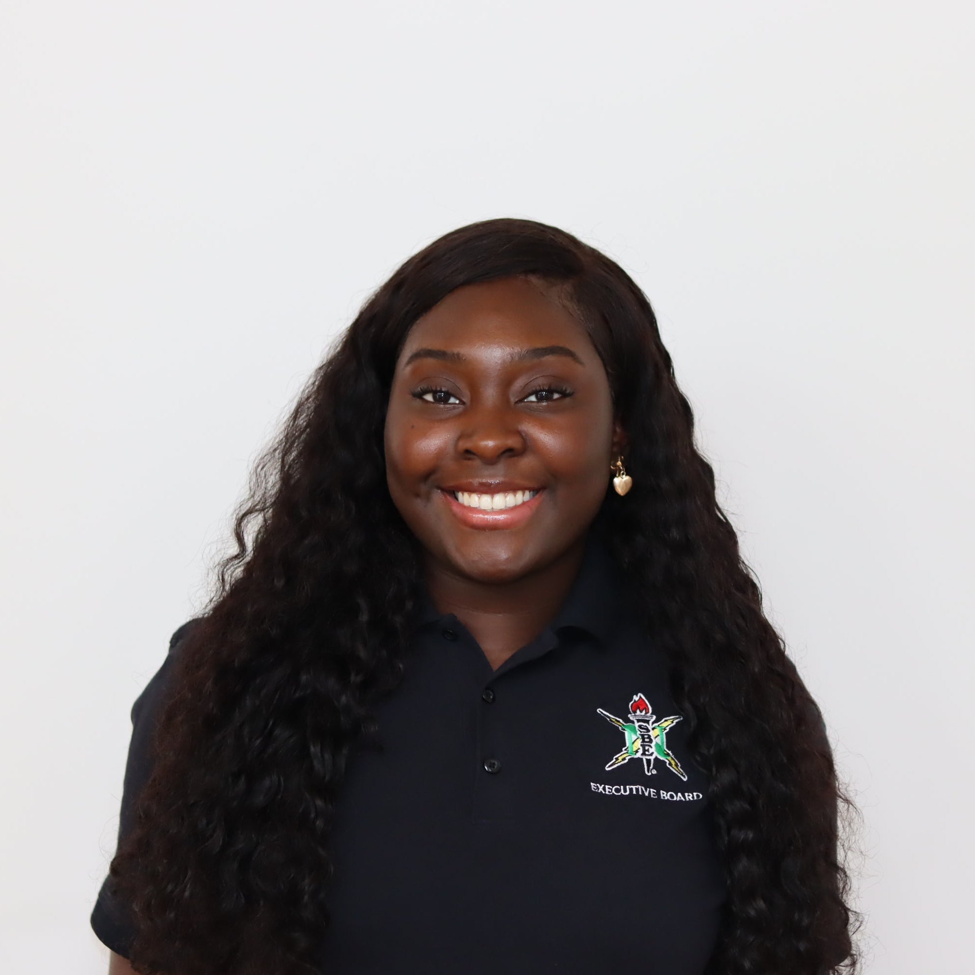 Woman wearing a black polo shirt with a logo on a white background