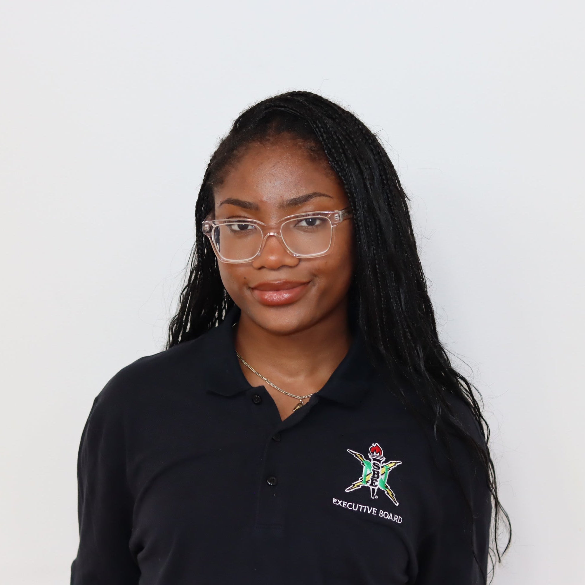 Person wearing a black polo shirt with a logo on a white background