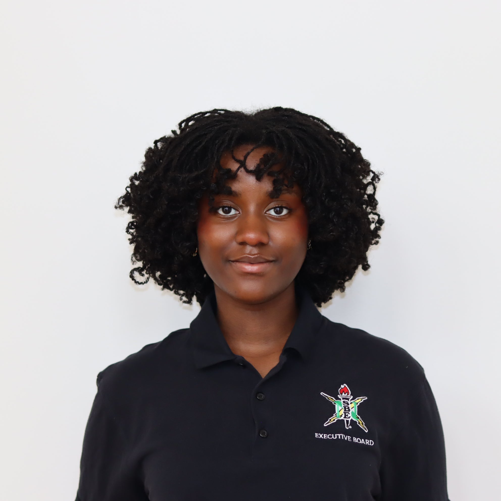 Person wearing a black polo shirt with a logo on a white background