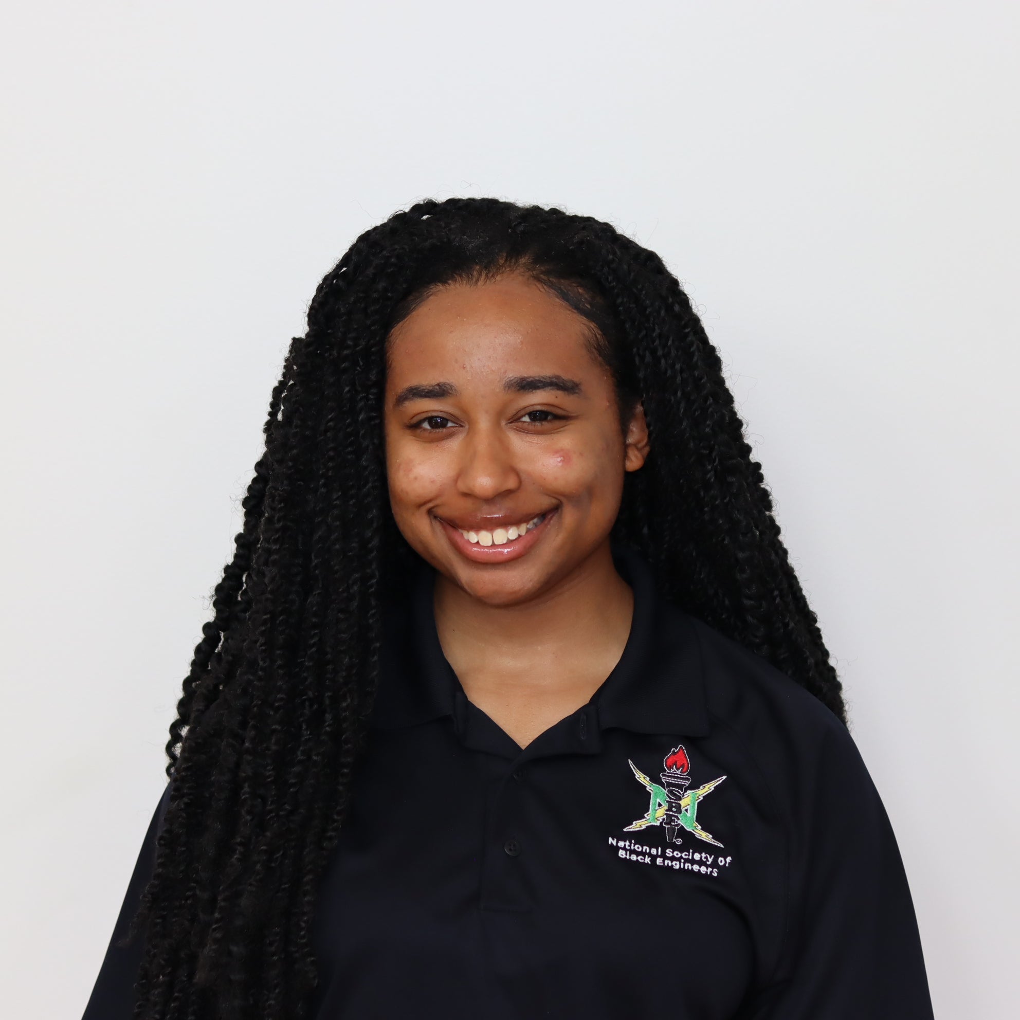 Person wearing a black polo shirt with a logo on a white background